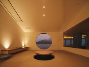 a round window in a room with a bench at Good Fellows Resort in Kagoshima +4 photos