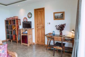 a living room with a desk and a television at LiRi Villa - Ocean, hills, valley view in Lovina