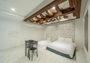 a bedroom with a white bed and a table at Gunsan Hasen Hotel in Gunsan-si
