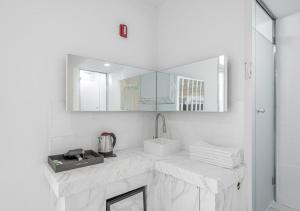 a white bathroom with a sink and a mirror at Gunsan Hasen Hotel in Gunsan-si