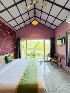 a bedroom with a large bed with purple walls at Himadri Retreat Wayanad in Kaniyāmbetta