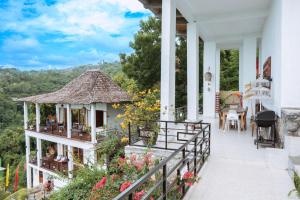 a house with a balcony with flowers on it at LiRi Villa - Ocean, hills, valley view in Lovina