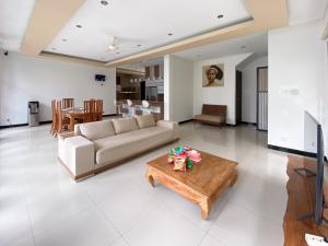 a living room with a couch and a table at The Lavana Dzawani Villa Berawa Kuta Bali 3 Bedroom Villa in Canggu
