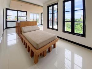 a bed in a room with windows at The Lavana Dzawani Villa Berawa Kuta Bali 3 Bedroom Villa in Canggu +96 photos