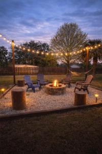 a fire pit in a yard with chairs and lights at Family Country Retreat w Pool, Games & Fire Pit in Clewiston