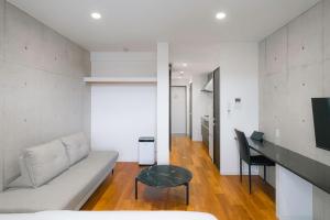 a living room with a couch and a table at メーアレジデンスホテル 宮古空港前 - Meer Residence Hotel Miyako Airport - in Miyako-jima