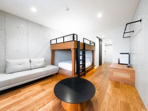 a living room with a bunk bed and a table at メーアレジデンスホテル 宮古空港前 - Meer Residence Hotel Miyako Airport - in Miyako-jima