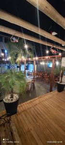 a wooden deck with tables and chairs and lights at Kitnet Diskbeer in Itaparica