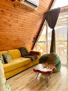 a living room with a yellow couch and a table at Yerankyun Boutique Cabin in Lermontovo
