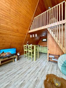a living room with a staircase and a table and a television at Yerankyun Boutique Cabin in Lermontovo