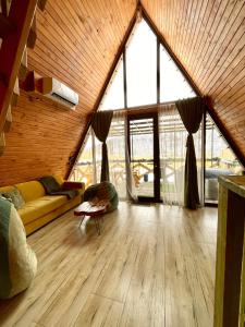 a living room with a couch and large windows at Yerankyun Boutique Cabin in Lermontovo