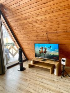 a flat screen tv in a room with a wooden ceiling at Yerankyun Boutique Cabin in Lermontovo