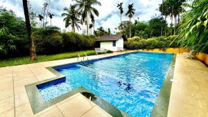 a swimming pool with blue water in a yard at Himadri Retreat Wayanad in Kaniyāmbetta