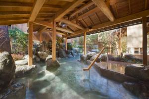 a pool of water with rocks in a house at Shimobe Hotel in Minobu