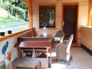 a table and chairs on the porch of a cabin at Feriendorf Reinskopf in der Eifel in Schönecken