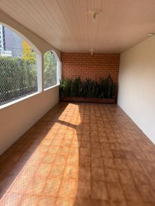 an empty room with a tile floor and a window at Espaço vovô Wilson in Joinville +4 photos