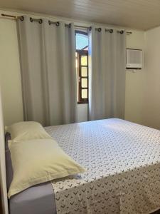a bedroom with a bed and a window at Espaço vovô Wilson in Joinville