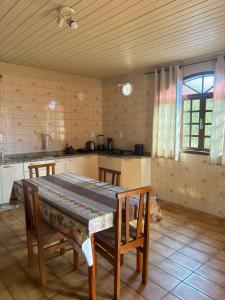 a kitchen with a table in the middle of a room at Espaço vovô Wilson in Joinville