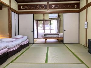 a room with two beds and a window at Tora House in Nagoya