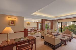a living room with a desk and a table at Hotel Cambodiana in Phnom Penh