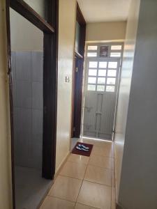 a bathroom with a walk in shower and a door at Arifa Homes in Ruringʼu