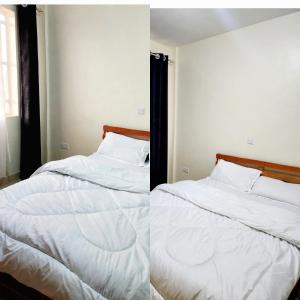 a bedroom with two beds with white sheets at Arifa Homes in Ruringʼu