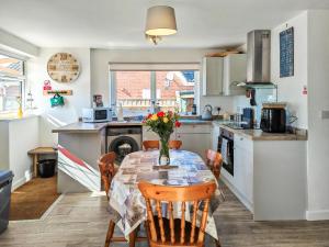 a kitchen with a table and chairs in a kitchen at Lilypots in Scratby