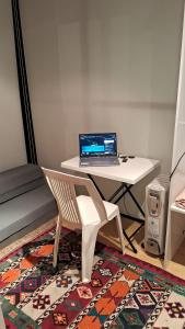 a laptop computer sitting on a desk with a chair at TinyHome Texcoco in San Miguel Coatlinchán
