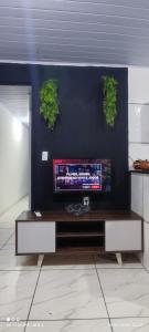 a living room with a tv on a wall at Kitnet Diskbeer in Itaparica