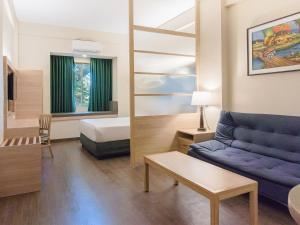ein Wohnzimmer mit Sofa und Bett in der Unterkunft Microtel by Wyndham Tarlac in Tarlac City