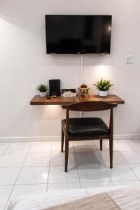 a wooden table with a television on a wall at The Oxford Suite in Kingston