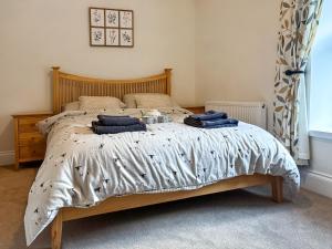 a bed with two blue pillows on it in a bedroom at Croft House Cottage in Hebden