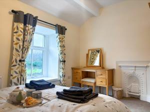 a bedroom with a bed and a desk and a window at Croft House Cottage in Hebden +22 photos