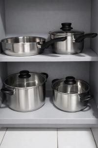 four pots and pans on a shelf in a kitchen at The Oxford Suite in Kingston +4 photos