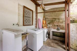 a dirty bathroom with a washing machine and a sink at Aqui, a vista é arte em Barequeçaba in São Sebastião +19 photos