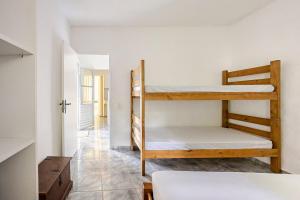 a room with two bunk beds and a hallway at Aqui, a vista é arte em Barequeçaba in São Sebastião