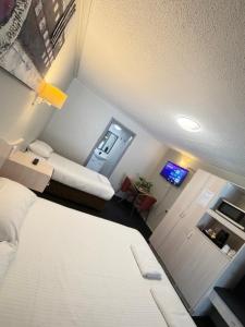 a small room with a white bed and a television at Centrepoint Motor Inn in Rockhampton