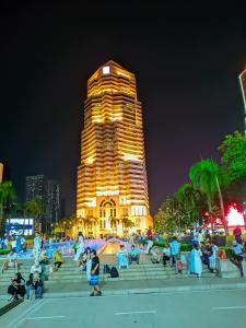 a group of people sitting on steps in front of a tall building at vortex Suites KLCC KL in Kuala Lumpur