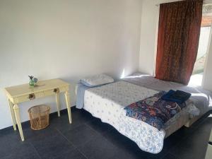 a small bedroom with a bed and a table at Beekind in San Juan Teotihuacán