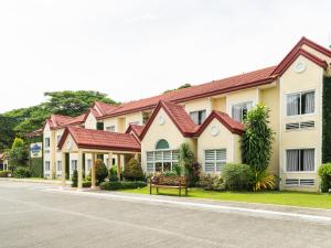 ein Haus mit einer Bank davor in der Unterkunft Microtel by Wyndham Tarlac in Tarlac City