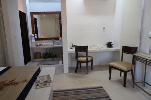a bedroom with a bed and a desk and two chairs at Hotel Casa de Campo Conkal Merida in Conkal +130 photos