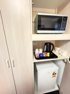 a microwave oven sitting on a shelf next to a refrigerator at Centrepoint Motor Inn in Rockhampton