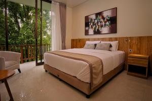a bedroom with a large bed and a balcony at Wikubu Villa in Munduk