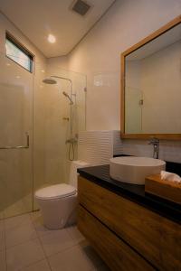 a bathroom with a sink and a toilet and a shower at Wikubu Villa in Munduk