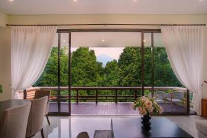a living room with a view of a balcony at Wikubu Villa in Munduk