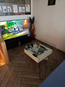 a living room with a table and a tv with a video game at Duplex 95m2 Annecy in Annecy