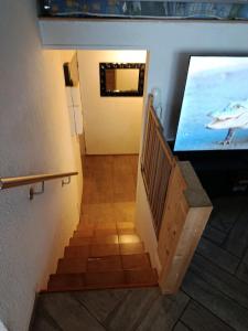 a hallway with a staircase with a tv on the wall at Duplex 95m2 Annecy in Annecy +1 photo