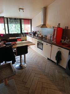 a kitchen with a wooden floor and a wooden table at Duplex 95m2 Annecy in Annecy