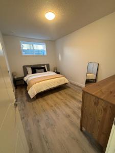 a bedroom with a bed and a wooden floor at Hidden Gem in Airdrie