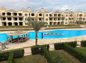 a large building with a swimming pool in front of it at شاليهات للايجار بالعين السخنه in Kafr Rāshid